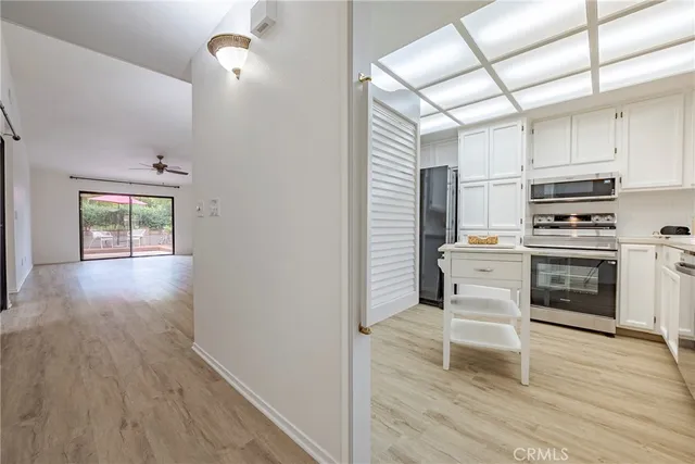 a white kitchen with a sink wooden floor and white cabinets