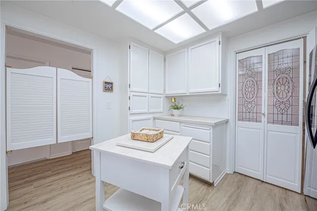 a kitchen with granite countertop white cabinets and stainless steel appliances