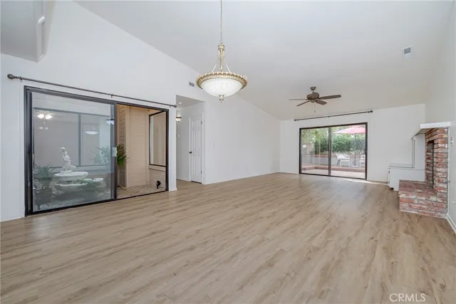 a view of a livingroom with wooden floor and a ceiling fan