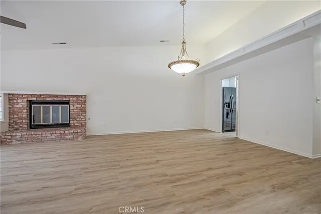 a view of an empty room with chandelier fan