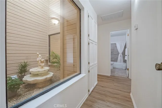a view of an empty room with chandelier fan and fire place
