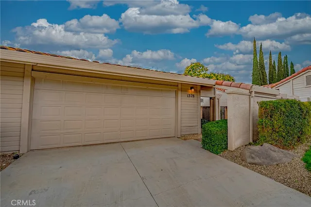 a front view of a house with a garden and yard