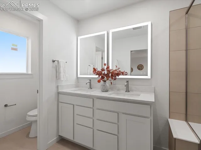 a bathroom with a toilet a sink and mirror