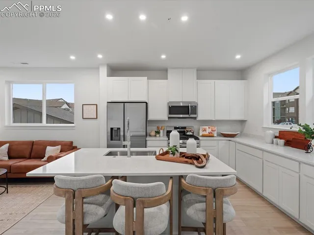 a kitchen with stainless steel appliances a sink a table and chairs