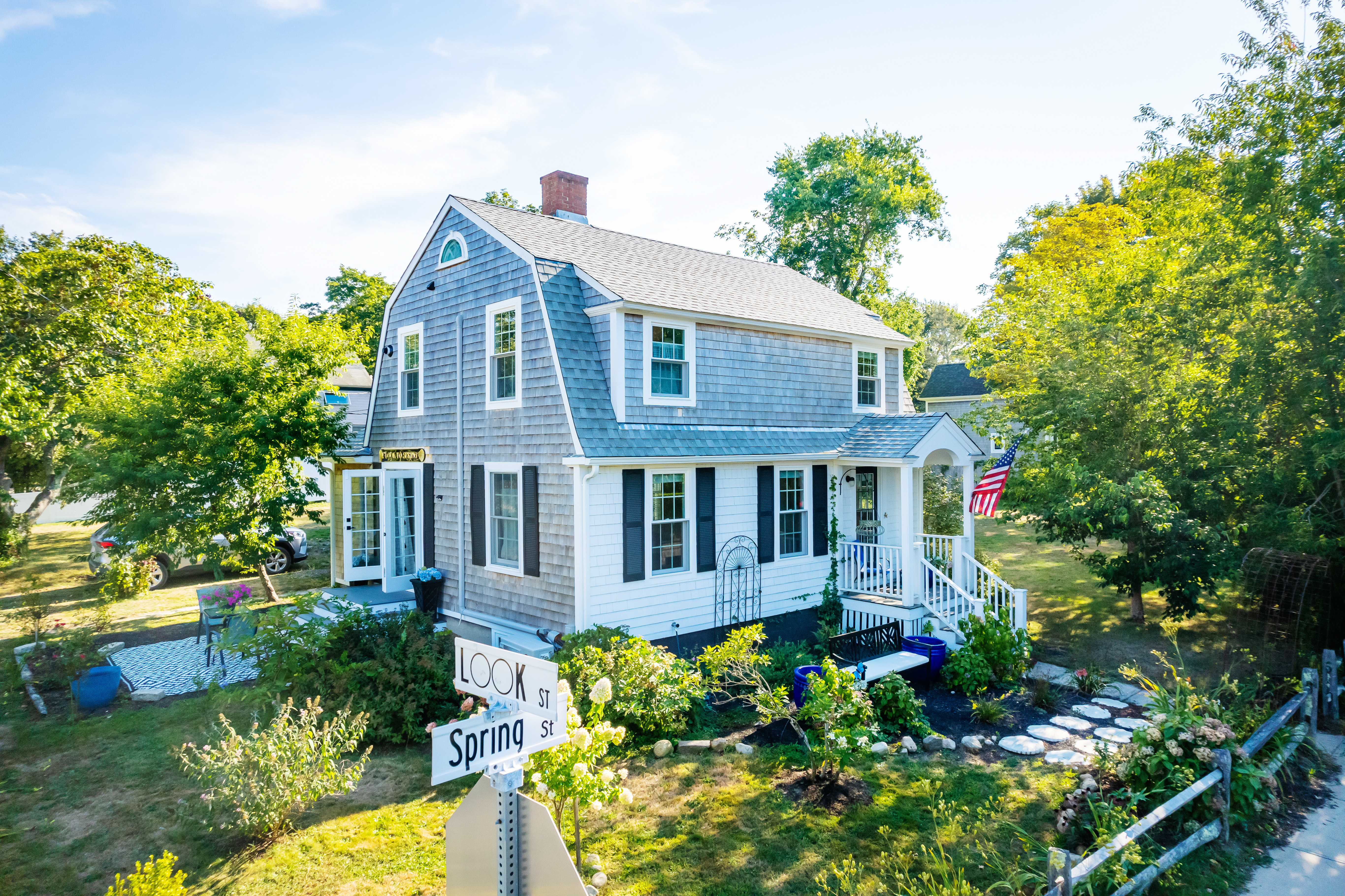 a front view of a house with a yard and potted plants