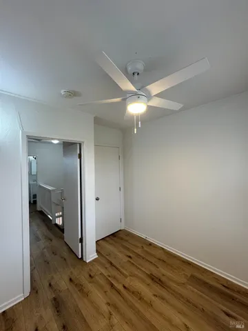 an empty room with wooden floor and mirror