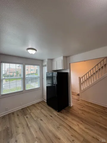 a view of a kitchen with wooden floor and a refrigerator