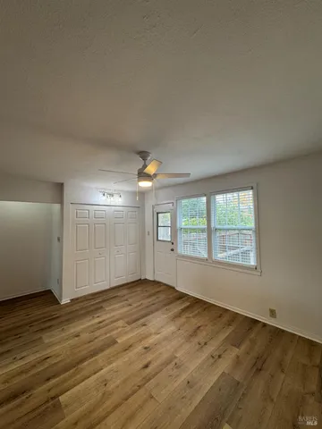 an empty room with wooden floor and windows