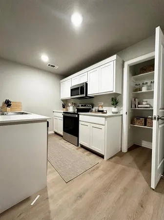 a kitchen with a sink a stove and cabinets