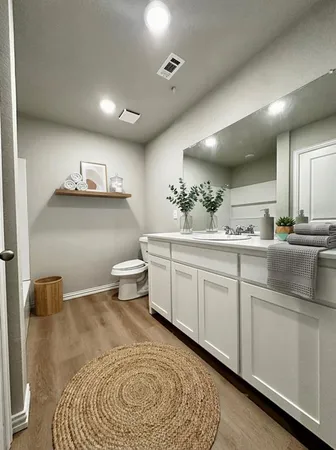 a spacious bathroom with a granite countertop sink and a toilet