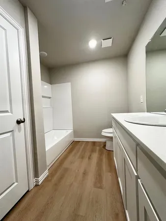 a bathroom with a sink a toilet a tub and a mirror