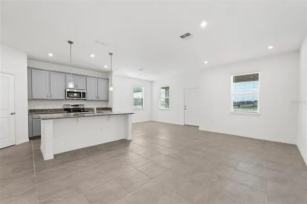 a view of kitchen with kitchen island a sink stainless steel appliances and cabinets