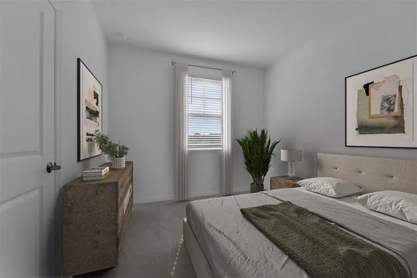 a bedroom with a bed and a potted plant