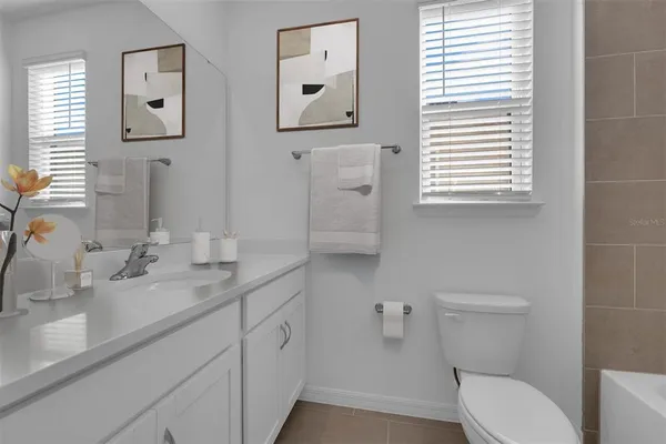 a bathroom with a toilet sink vanity and mirror