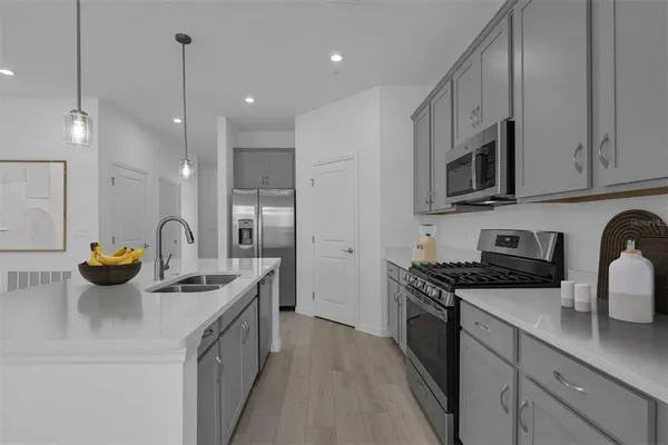 a kitchen with stainless steel appliances granite countertop a sink a stove and a refrigerator