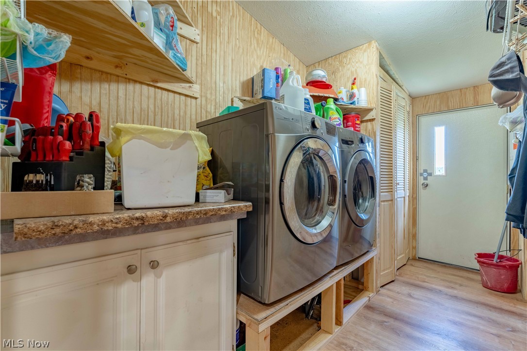 5267 Apollo Road Northeast Salineville, OH 43945 - Photo 13 of 33 Laundry room featuring washing machine and clothes dryer, light wood-style flooring, and a textured ceiling