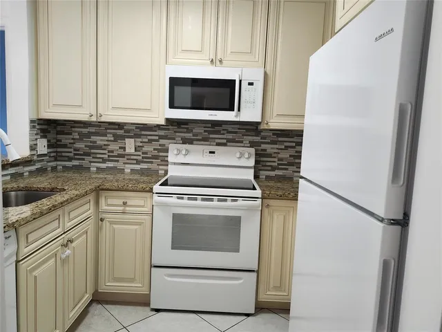 a kitchen with white cabinets and white appliances