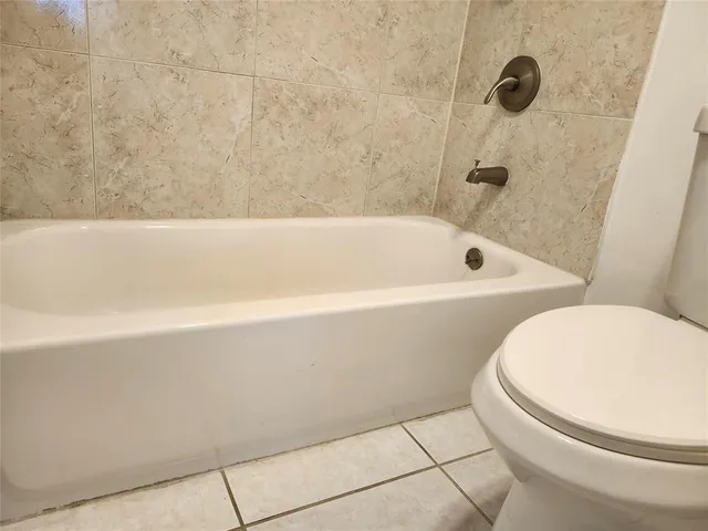 a bathroom with a toilet and a bath tub