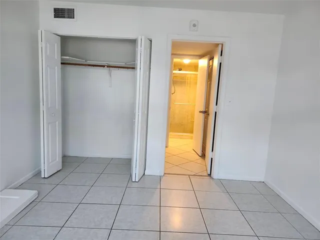 an empty room with a bathroom and mirror