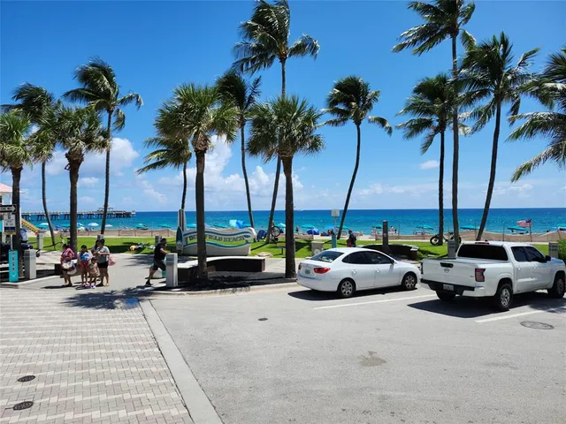 a view of parked car with palm trees