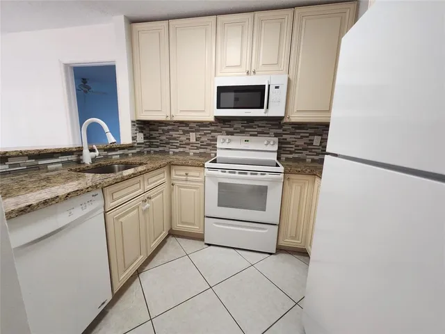 a kitchen with white cabinets appliances and sink