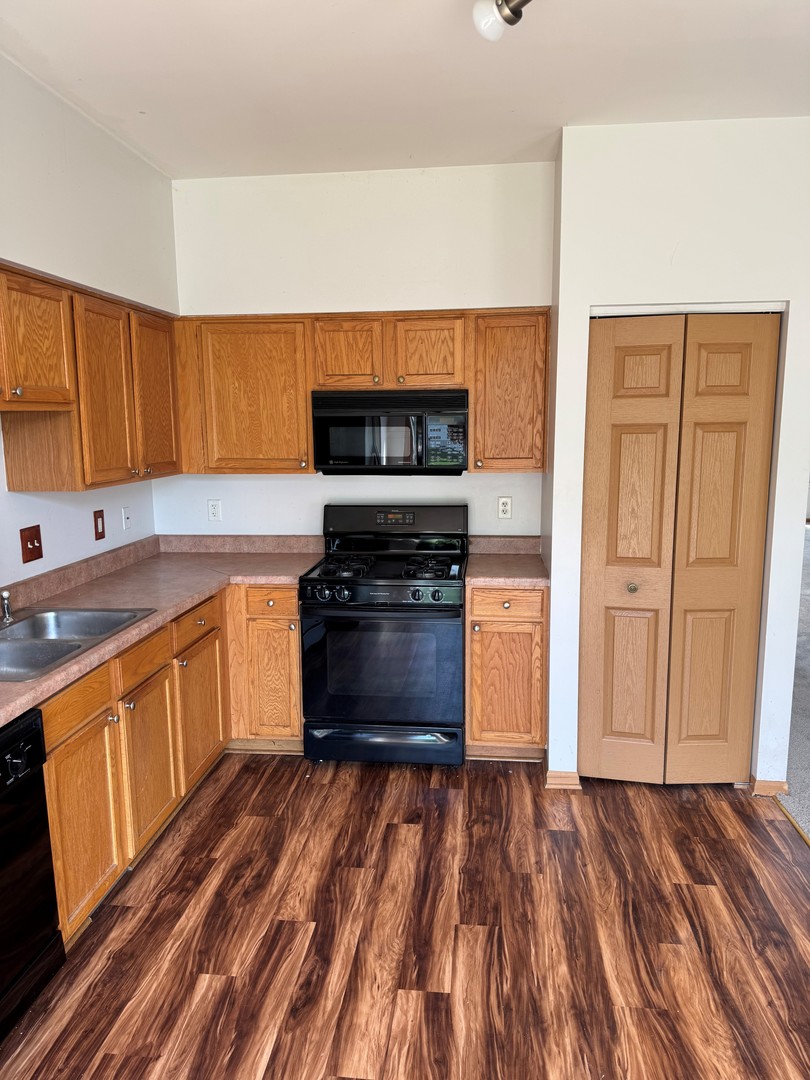 674 Shannon Drive, Unit 674 Romeoville, IL 60446 - Photo 6 of 13 a kitchen with wooden floors and a stove