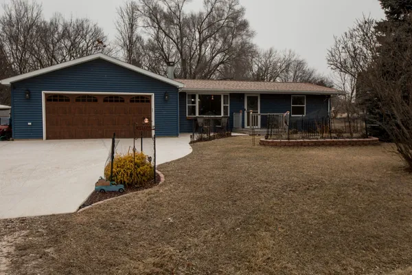 a front view of a house with a yard and parking space