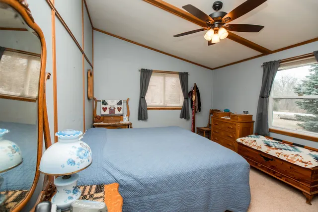 a bedroom with furniture and a mirror