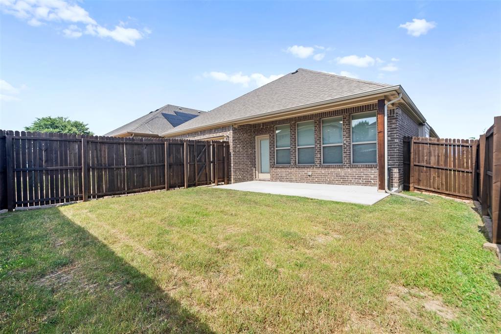 119 Happy Lane Red Oak, TX 75154 - Photo 34 of 37 Expansive grassy area featuring a concrete patio, full privacy fencing, and a brick exterior with multiple windows
