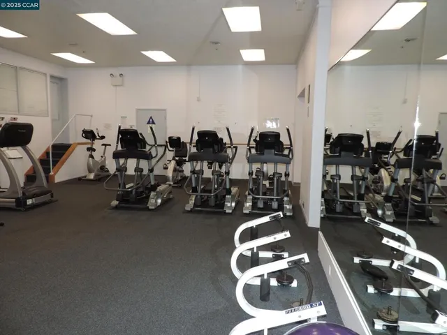 a room with gym equipment and large mirror
