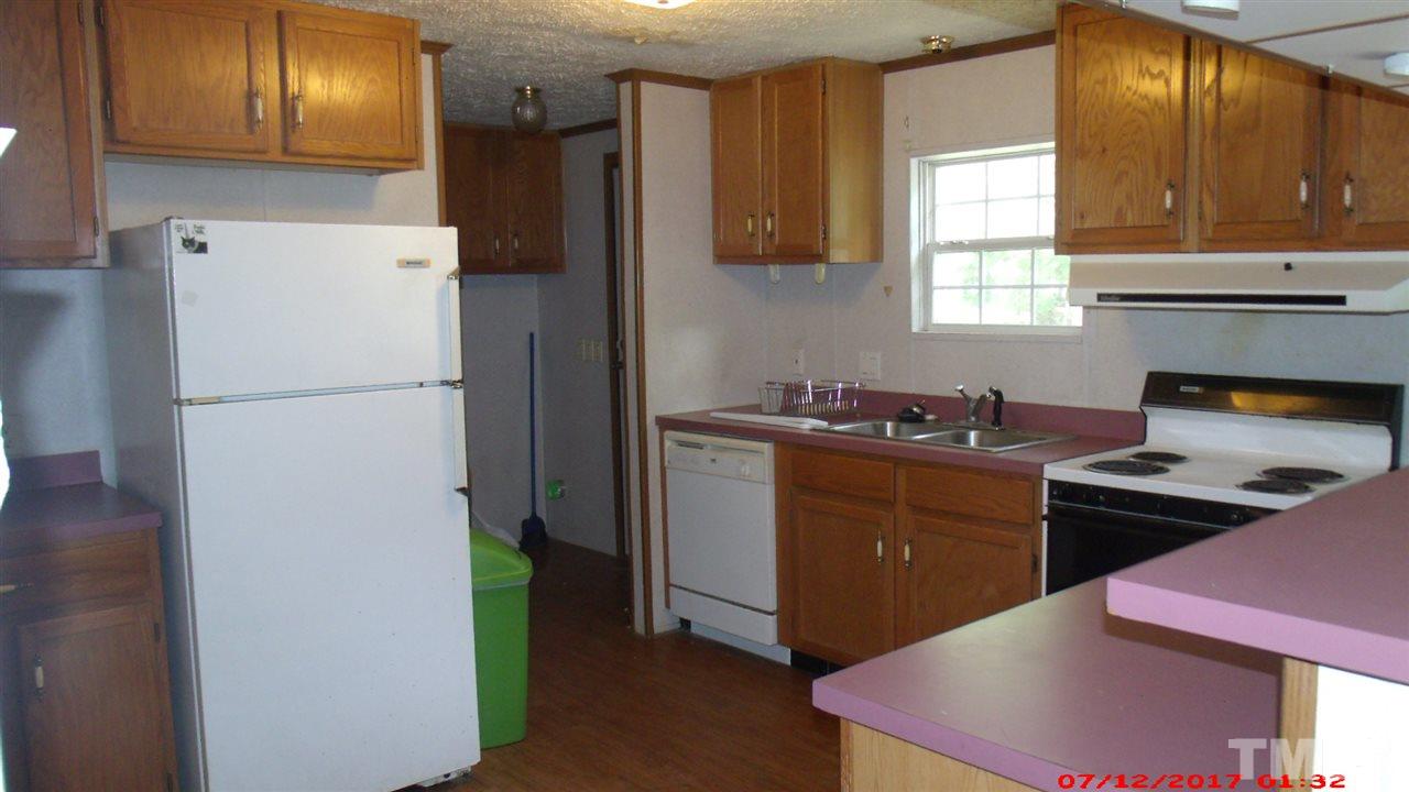 1129 Taos Trail Raleigh, NC 27603 - Photo 2 of 10 a kitchen with a refrigerator and a stove
