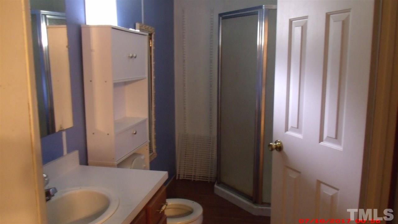 1129 Taos Trail Raleigh, NC 27603 - Photo 7 of 10 a bathroom with a granite countertop sink toilet and shower