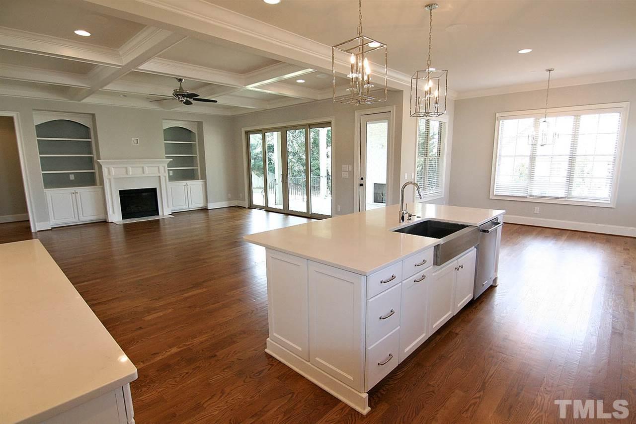4011 Edwards Mill Road Raleigh, NC 27612 - Photo 14 of 25 a large white kitchen with granite countertop a stove and a wooden floor