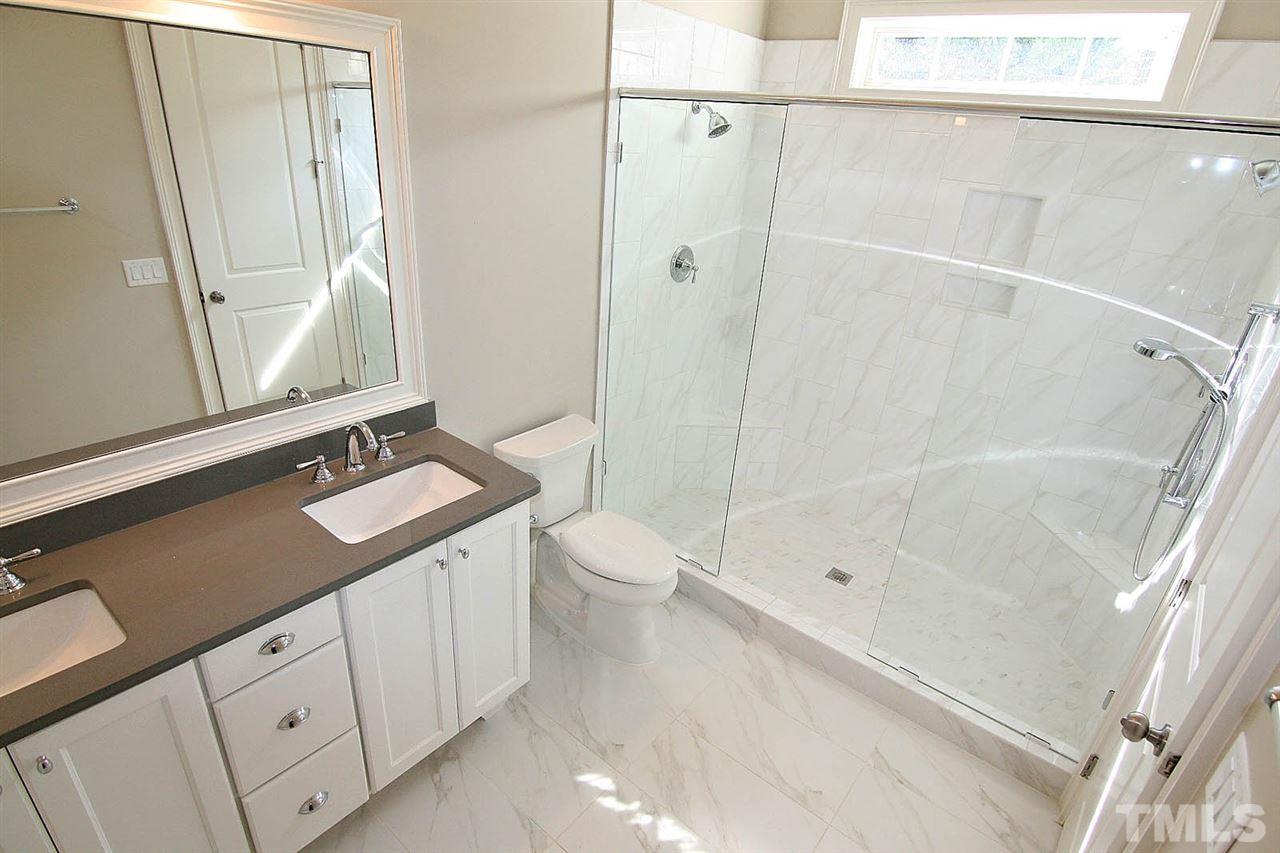 4011 Edwards Mill Road Raleigh, NC 27612 - Photo 17 of 25 a bathroom with a granite countertop sink toilet a shower and a mirror