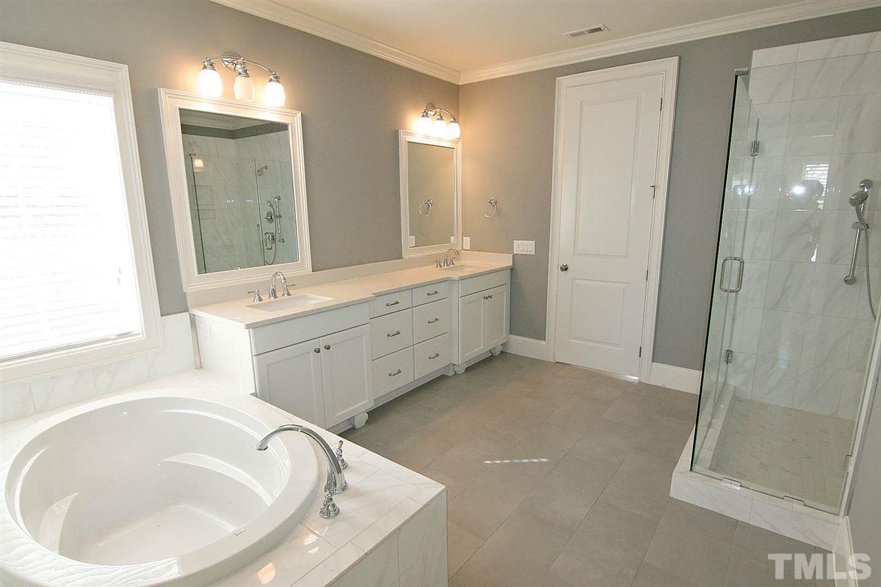 4011 Edwards Mill Road Raleigh, NC 27612 - Photo 20 of 25 a spacious bathroom with a bathtub sink and mirror