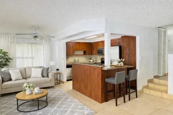 a living room with furniture and kitchen view