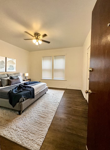 10749 South State Street Chicago, IL 60628 - Photo 21 of 31 a bedroom with a large bed and a chandelier
