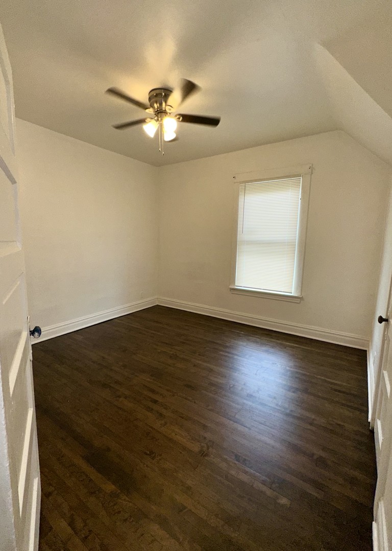 10749 South State Street Chicago, IL 60628 - Photo 22 of 31 an empty room with wooden floor and windows