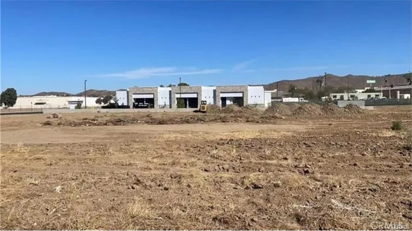 a view of a dry yard with wooden fence
