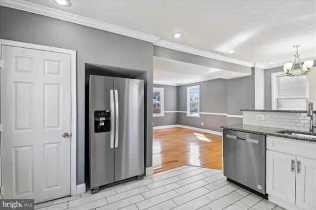 a large kitchen with stainless steel appliances granite countertop a refrigerator and a sink