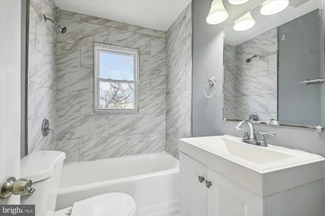 a bathroom with a sink mirror toilet and bathtub