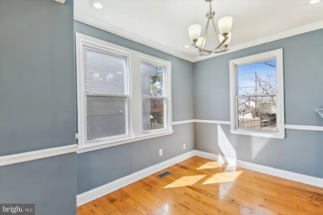 a view of a bedroom with wooden floor and windows