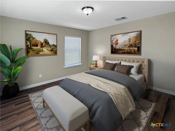 a bedroom with a bed and a painting on the wall