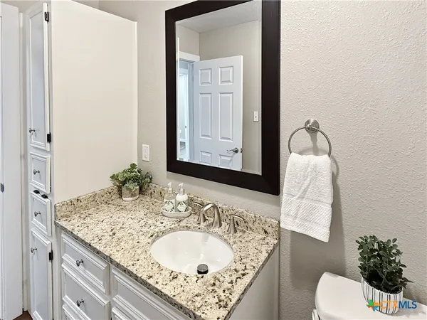 a bathroom with a granite countertop sink and a mirror