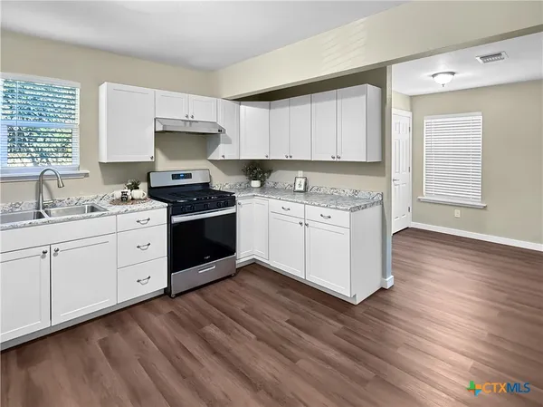 a kitchen with a stove a sink and a microwave