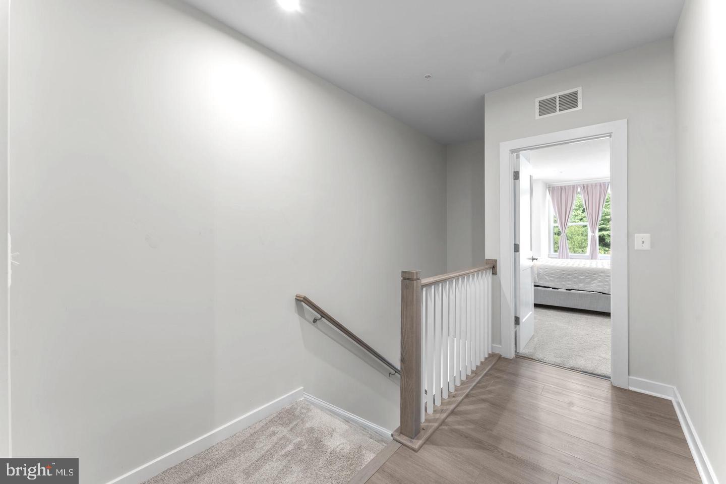43785 Transit Square Ashburn, VA 20147 - Photo 11 of 40 a view of a hallway with a bedroom and wooden floor