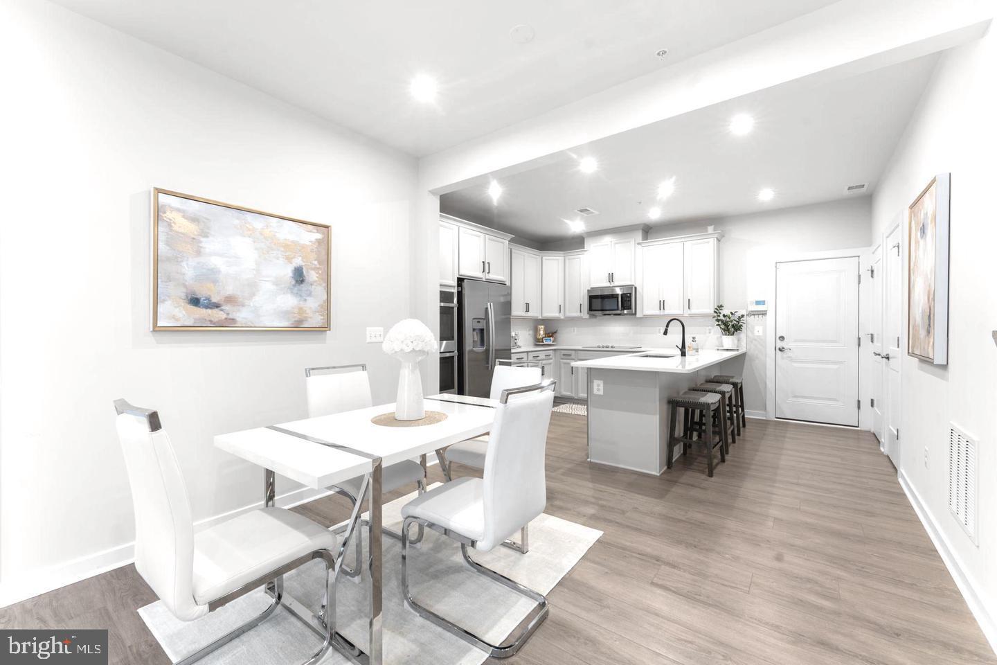 43785 Transit Square Ashburn, VA 20147 - Photo 5 of 40 a kitchen with a dining table chairs refrigerator and cabinets