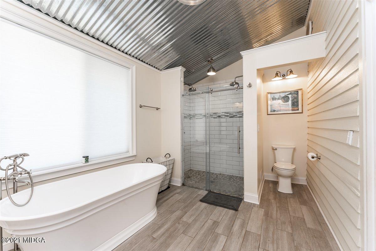 96 Gose Road Forsyth, GA 31029 - Photo 19 of 38 a spacious bathroom with a granite countertop tub toilet a sink and a shower