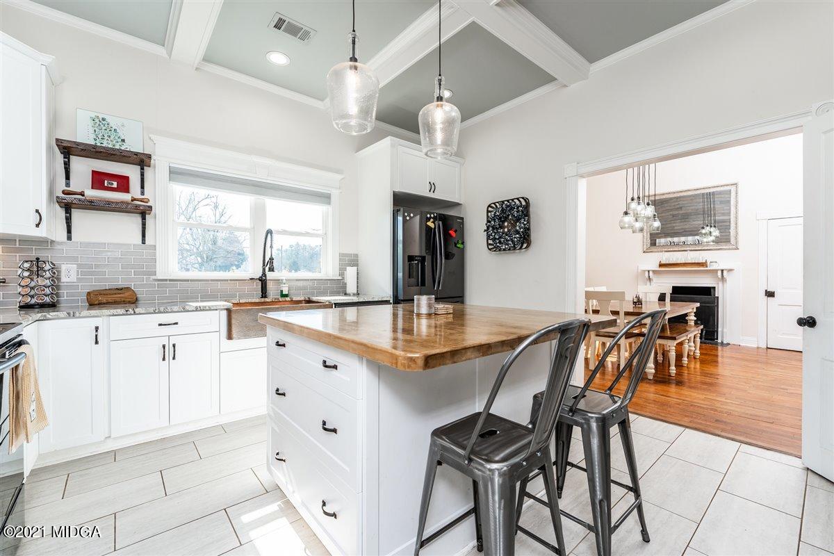 96 Gose Road Forsyth, GA 31029 - Photo 4 of 38 a kitchen with granite countertop cabinets a dining table and chairs