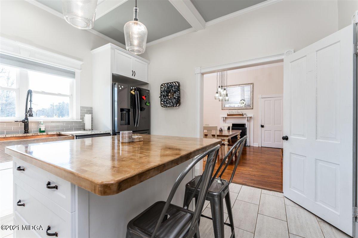 96 Gose Road Forsyth, GA 31029 - Photo 9 of 38 a kitchen with stainless steel appliances granite countertop a table chairs and stove